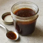 Easy Balsamic Vinaigrette served in a small glass jar with a teaspoon