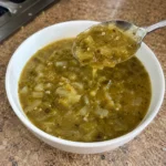 Bowl of Hatch Green Chile Sauce with a spoon showing its pourable texture