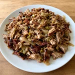 Square recipe card image of Tender Slow Cooker Hatch Green Chili Pork Carnitas Recipe served on a white plate