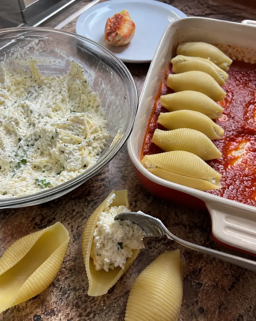 Filling jumbo pasta shells with ricotta mixture for the Stuffed Shells recipe