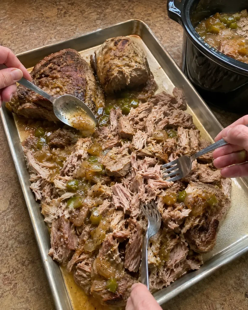 Shredding cooked pork and adding Hatch green chile juices before broiling the carnitas
