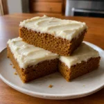 Stack of Pumpkin Bars showing moist pumpkin cake and cream cheese frosting