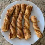 Golden Pumpkin Pie Twists arranged on a plate with visible pumpkin filling