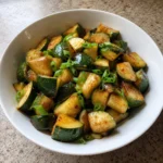 Easy Zucchini Stir-Fry served in a white bowl with scallions