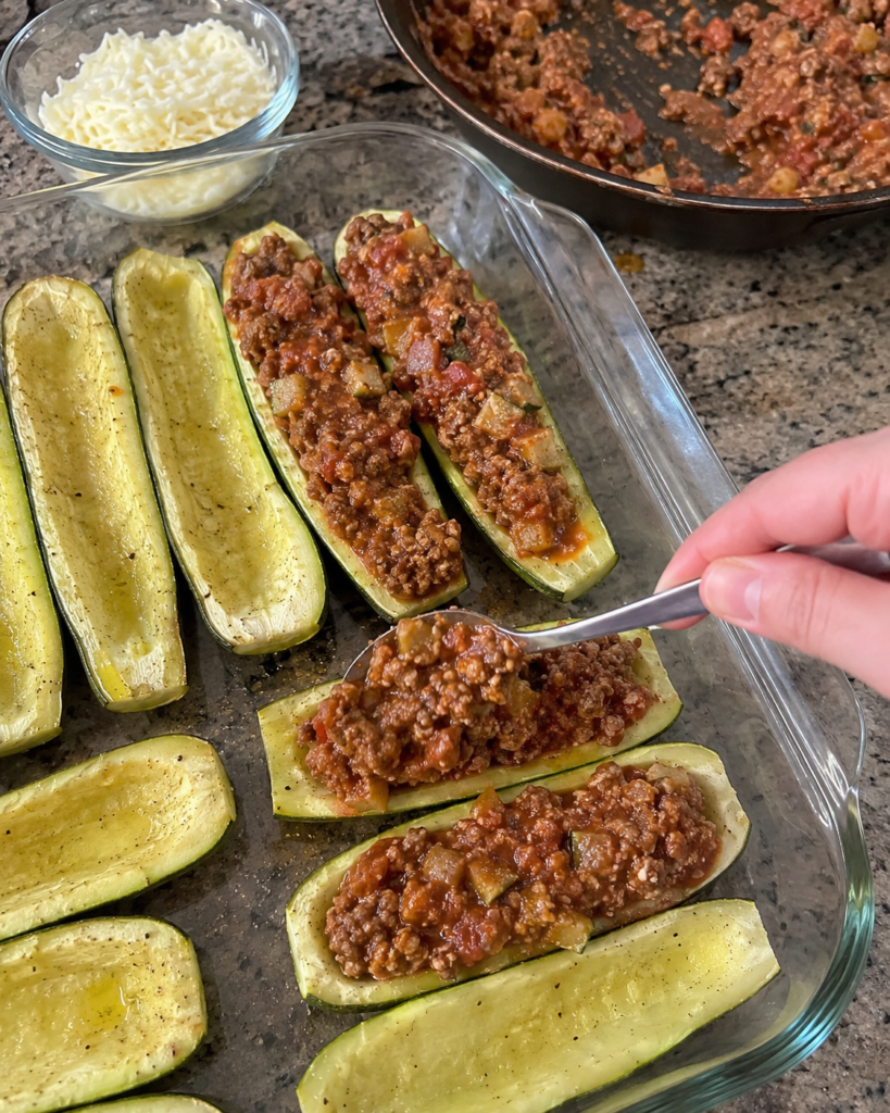 Two Stuffed Zucchini halves filled with beef and tomato sauce and topped with mozzarella