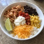 Lazy High Protein Dinner bowl topped with salsa, Greek yogurt, and shredded cheddar