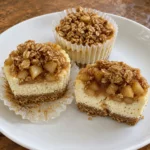 Three Apple Crisp Mini Cheesecakes showing the graham crust and creamy apple-filled center