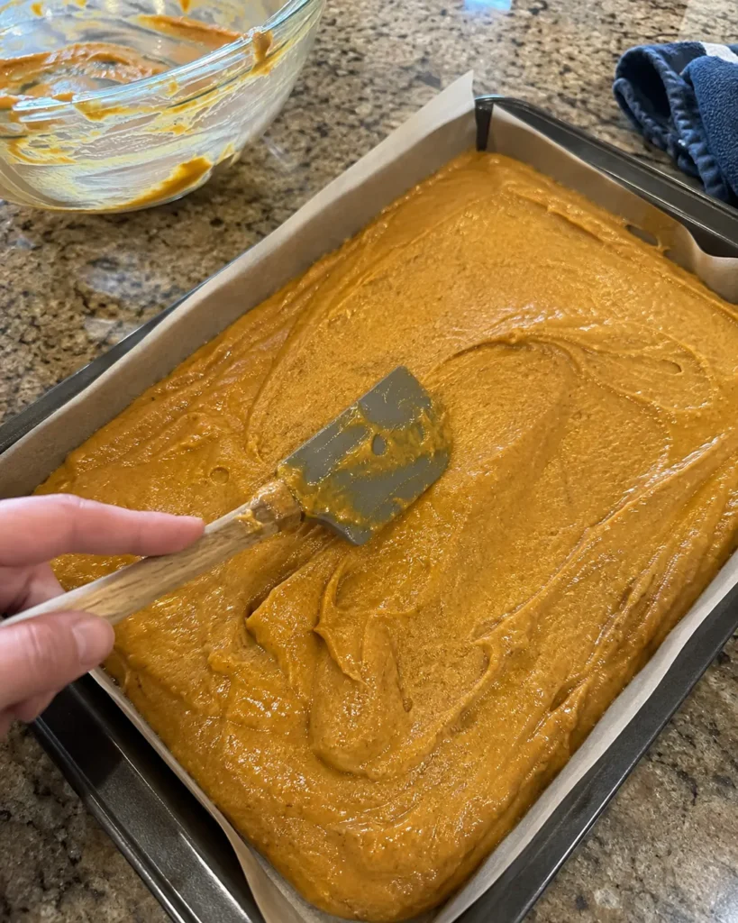Pumpkin Bars batter being spread into a rimmed baking pan before baking