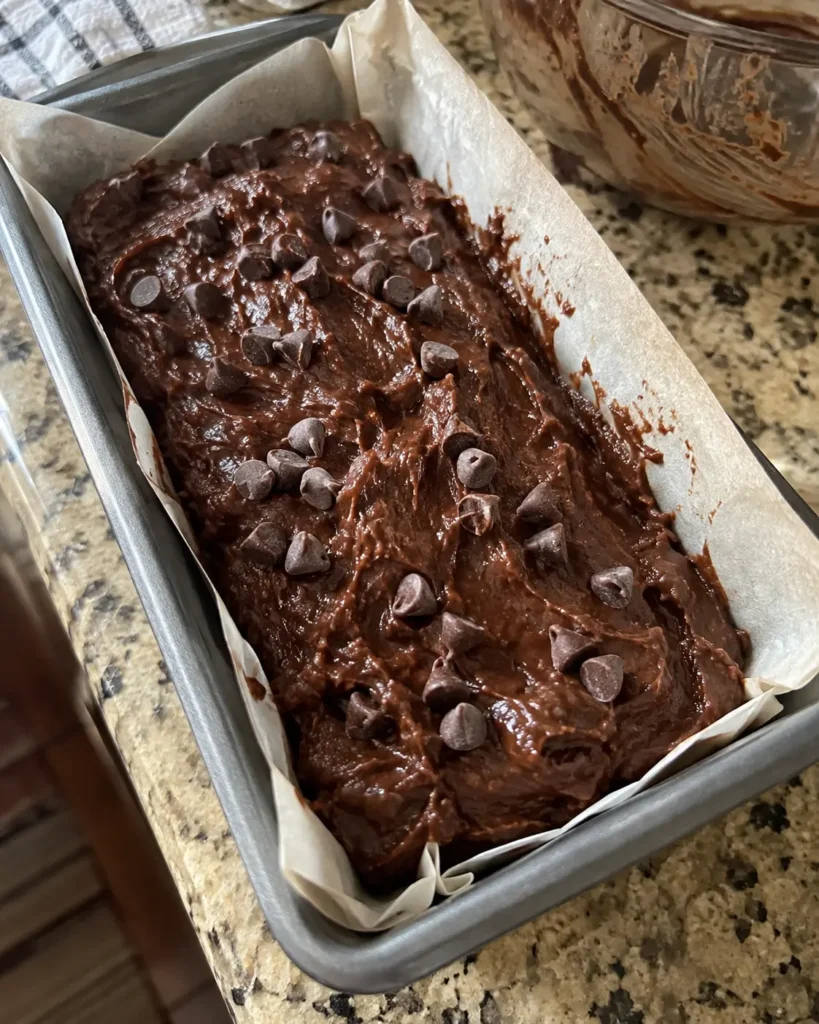 Chocolate Pumpkin Bread batter in a parchment-lined loaf pan