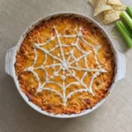 Overhead Halloween Buffalo Chicken Dip with cheddar cheese and a sour-cream spiderweb