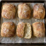 Homemade crusty ciabatta bread rolls on parchment paper