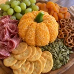 Pumpkin Themed Charcuterie Board with a cheddar cheese ball and fall snacks